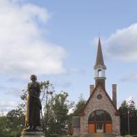 Vue classique de la statue d’Évangéline et de l’église souvenir au lieu historique national du Canada de Grand-Pré